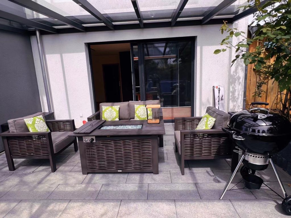 Rattan weave outdoor sofa, including 2 armchairs and 1 two-seater sofa, in a residential garden.